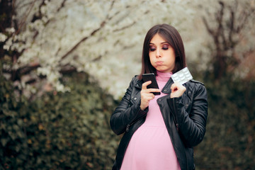 Pregnant Woman Holding Pills Checking Smartphone