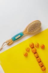 Anti-cellulite brush for dry body massage.   Oranges are laid out in the shape of an arrow. Healthy lifestyle, Prevention of cellulite.