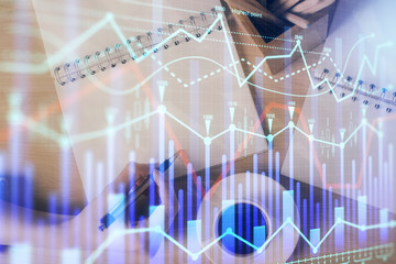 Multi exposure of woman's hands making notes with forex graph hologram. Concept of technical analysis.