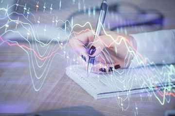 Multi exposure of hands making notes with forex chart huds. Stock market concept.