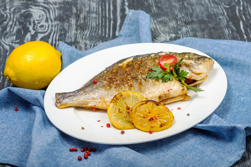 Exquisite white grilled fish with lemon in restaurant serving