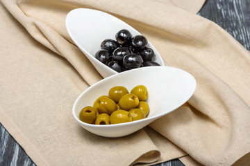 Snack of olives and olives in white porcelain bowls in restaurant serving