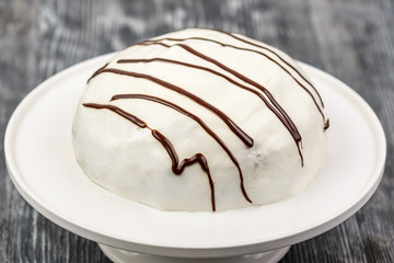 Dessert biscuit cake with sour cream and walnut sprinkle on a white napkin