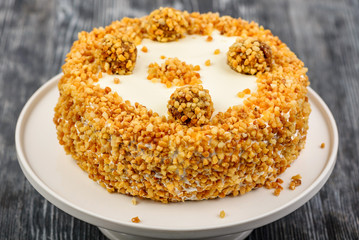 Dessert biscuit cake with vanilla cream, sprinkle of roasted nuts and homemade sweets