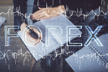 Forex chart hologram on hand taking notes background. Concept of analysis. Multi exposure
