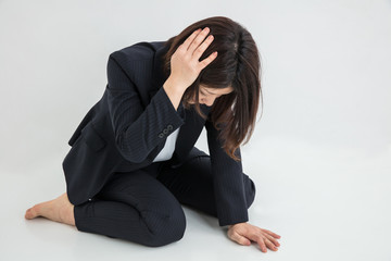 スーツの女性　頭を抱える　悲しい　辛い　woman