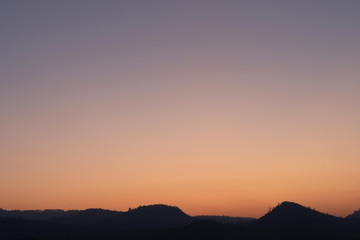 Heaven at early morning with copy space. Smooth orange blue gradient of dawn sky.Sunset, sunrise backdrop.Predawn clear sky with orange horizon and blue atmosphere.  Background of beginning of day.