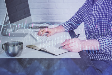 Double exposure of stock market chart with man working on computer on background. Concept of financial analysis.