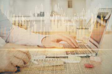 Multi exposure of stock market graph with man working on laptop on background. Concept of financial analysis.