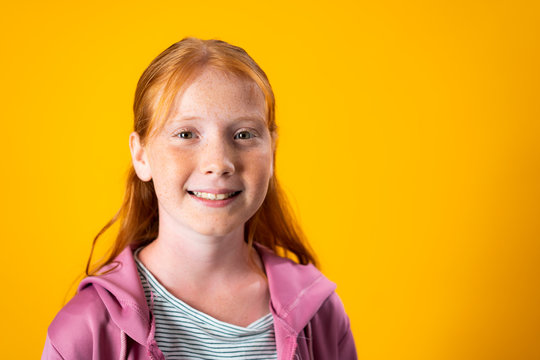 Portrait of a Beautiful Red-Haired Teenager Looking at Camera