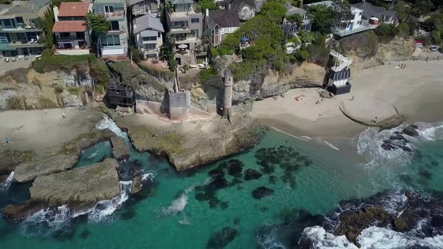Victoria beach coast, Aerial Orbit above colorful urban coastal house rooftops and Pirate Tower, Laguna