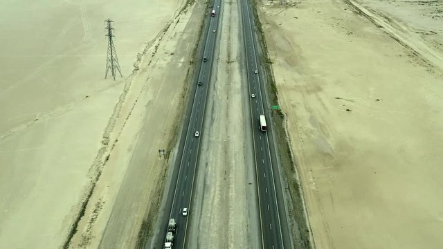Aerial footage over trucks and cars on the fifteen freeway in the Mojave Desert