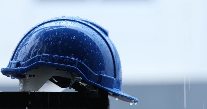 Raindrops on a construction helmet,heavy rain and construction safety helmets, blue hard safety helmet and raining