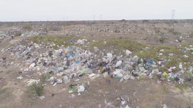 Left traveling aerial drone view move of garbage in the Sechura Desert in Lambayeque Region, Peru