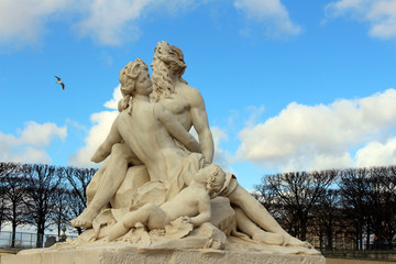 Sculpture in the central park of Paris with depicted people adults and children against the sky