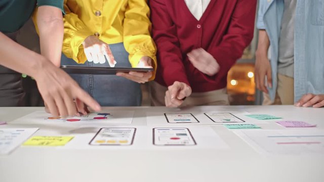 Young Asian business creative developer team work together at night, mobile application software design project. Brainstorm meeting, UI/UX technology, office coworker teamwork concept. 4K panning shot