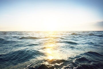 Clear blue sunset sky above the Baltic sea. Golden evening sunlight reflecting in the water. Ruhnu...