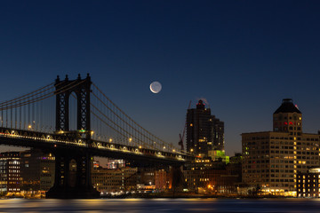 View on Manhattan bridge and Dumbo neighborhood during  waxing Crescent moonrise, with long exposure