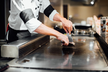 Hand of man take cooking of meat with vegetable grill, Chef cooking wagyu beef in Japanese teppanyaki restaurant