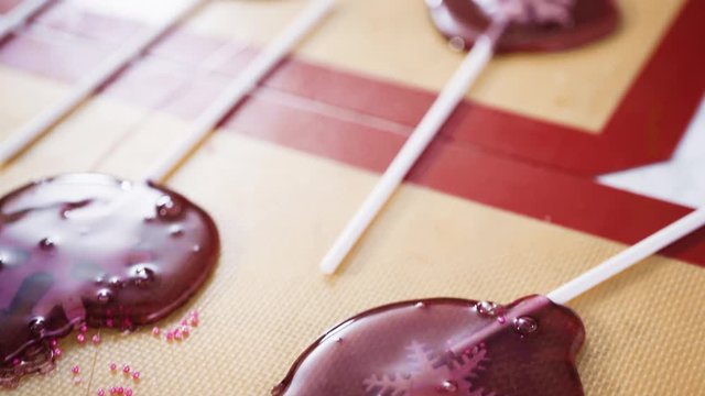 Close up view. Making homemade berry flavor lollipops with snowflakes.
