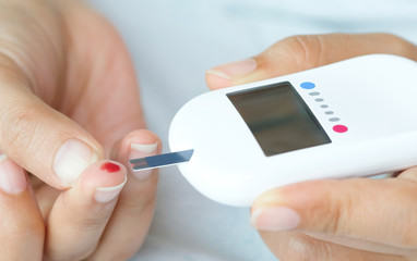 hand of people check diabetes and high blood glucose monitor with digital pressure gauge. Healthcare and Medical concept