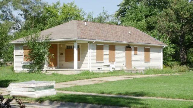 Detroit Eviction Abandoned House with Boarded Doors and Windows Mattress on Curb