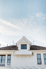 Roof of a White House with Window and Blue Sky - 328209873