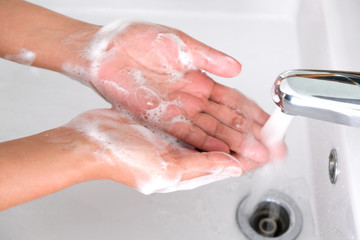 Fototapeta premium hand of beauty woman wash your hands at the wash basin with foam, cleanse the skin and have water flowing through the hands. Health and beauty concepts