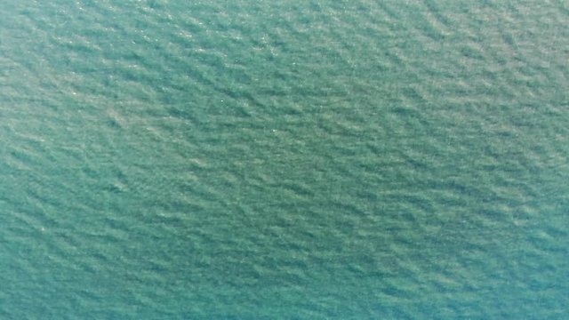 Sun and water texture graphic element. Drone aerial shot of water looking straight down. Waves and sunlight beams on crystal clear sea water on infinite ocean. Endless water waves graphic element.