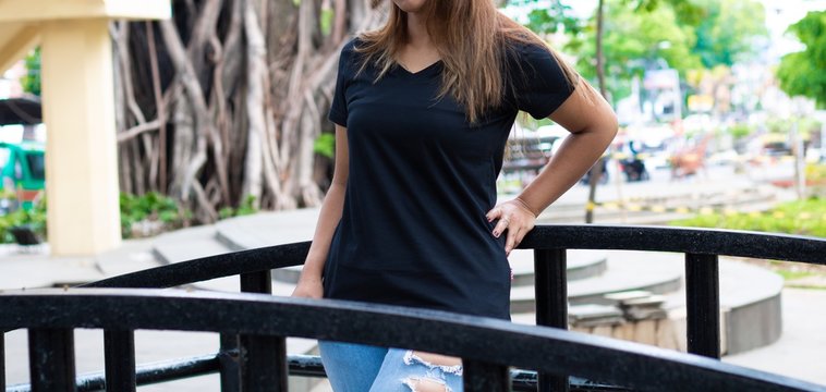 Female wearing black t shirt posing at park in front view, suitable for mock up template, background, etc.