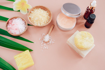 Flatlay composition with bowls of bath salt, serum, essential oil, solid shampoo and organic soap on pink color background. Spa and Beauty treatment. Zero waste, organic cosmetics concept.