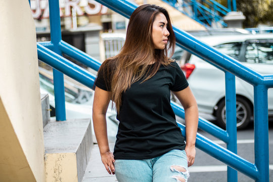 Young woman wearing black t shirt posing at footbridge, suitable for mock up template, etc.