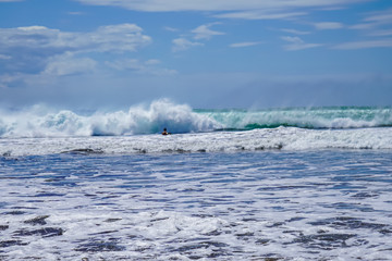 Beautiful aerial view of surfers surfing in Naranjo Beach 