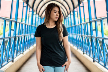 Young woman wearing black t shirt posing at footbridge, suitable for mock up template, etc.