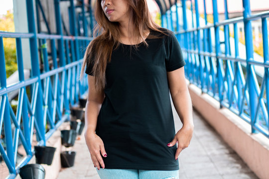 Young woman wearing black t shirt posing at footbridge, suitable for mock up template, etc.