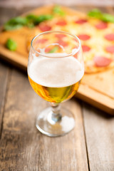 Freshly brewed beer and pepperoni pizza in bar. Selective focus. Shallow depth of field.