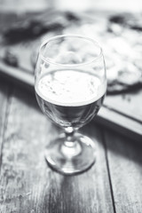 Freshly brewed beer and pepperoni pizza in bar. Black and white image.  Selective focus. Shallow depth of field.