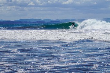Beautiful aerial view of surfers surfing in Naranjo Beach 