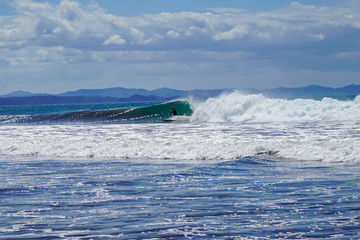 Beautiful aerial view of surfers surfing in Naranjo Beach 