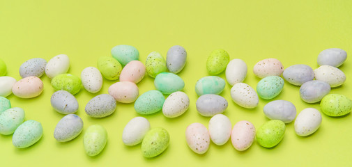Scattered pastel Easter eggs on green
