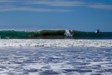 Beautiful aerial view of surfers surfing in Naranjo Beach 