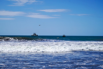 Beautiful aerial view of surfers surfing in Naranjo Beach 