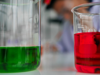 the Asian Thai Young medical doctor scientist testing color liquid in glassware test tube in the clinical laboratory for Virus infection cure 