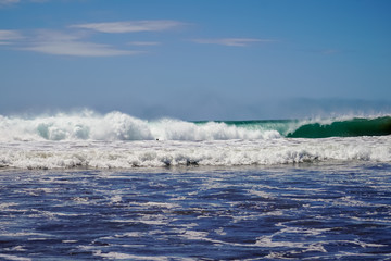 Fototapeta premium Beautiful aerial view of surfers surfing in Naranjo Beach 