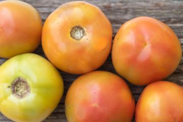 Unripe tomatoes on a rustic wooden background