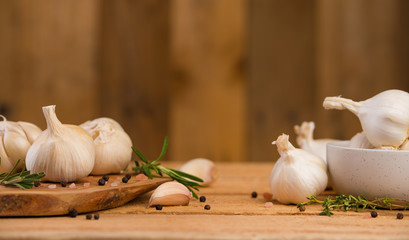 Spicy background of garlic and spices, rosemary, black pepper, and thyme. Concept of cooking, recipe book and home cooking.