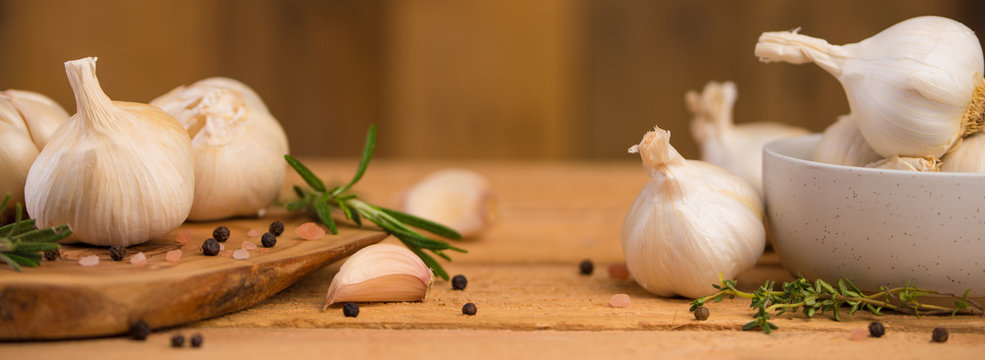 Banner with garlic and drunkenness on a wooden background, food and cooking saver, recipe book, fresh spices, rosemary and thyme, black pepper peas