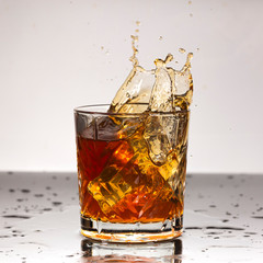 surge of mood A splash of whiskey or cognac in an old-fashioned glass. Motion blur.