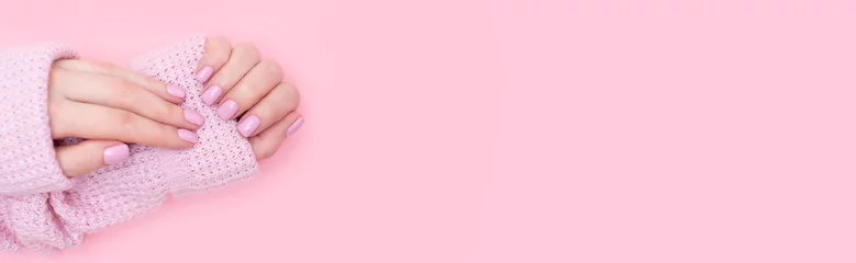 Poster Abgeschnittenes Bild eines Mädchens in Jeans und einem T-Shirt mit einer roten Blume in den Händen mit einer Maniküre auf weißem Hintergrund © Ксения Овчинникова