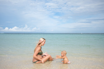 Happy pregnan mother with little daughter on beach